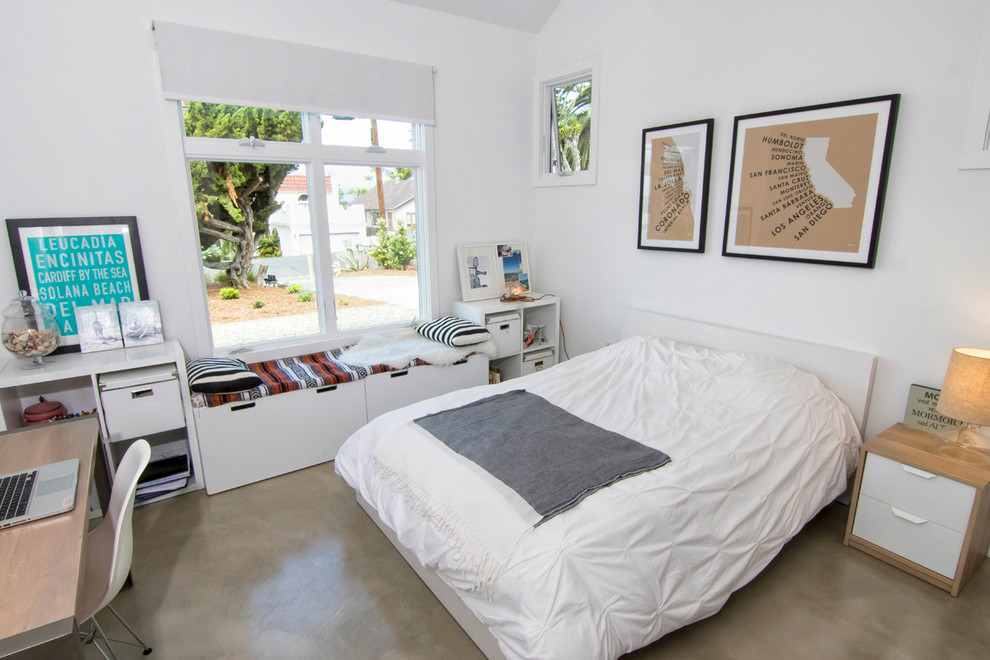 Inspiration for a mid-sized coastal guest concrete floor bedroom remodel in San Diego with white walls