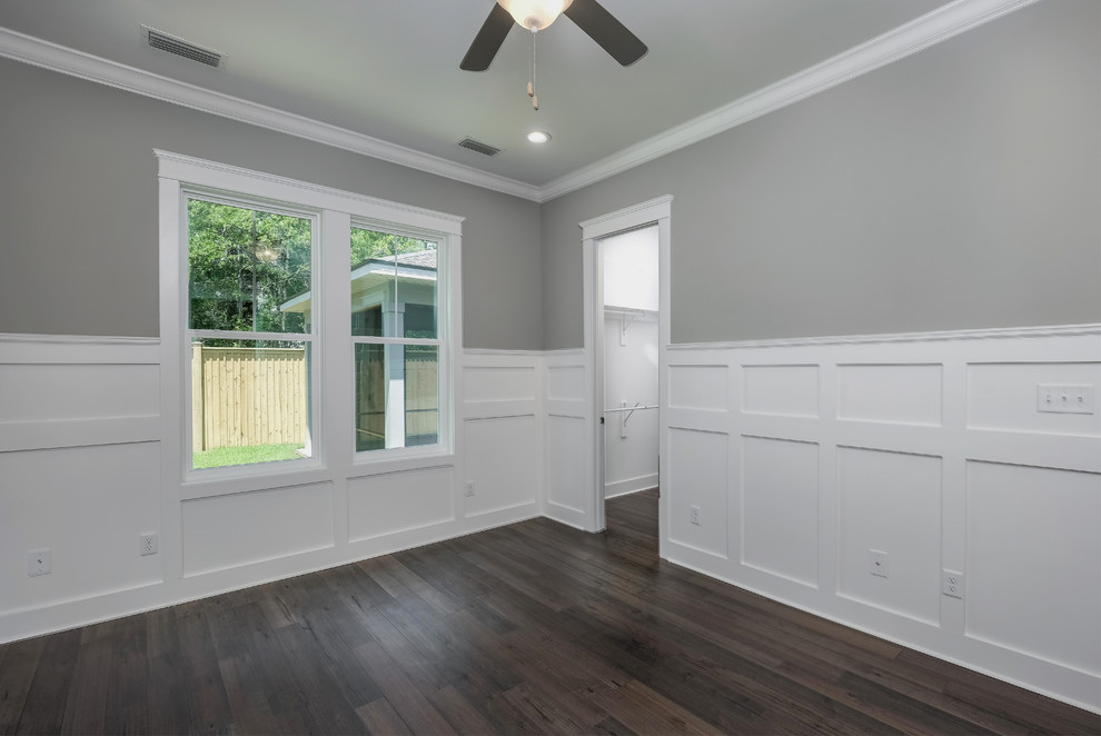 Ejemplo de dormitorio principal de estilo americano de tamaño medio con paredes grises, suelo de madera en tonos medios y suelo marrón