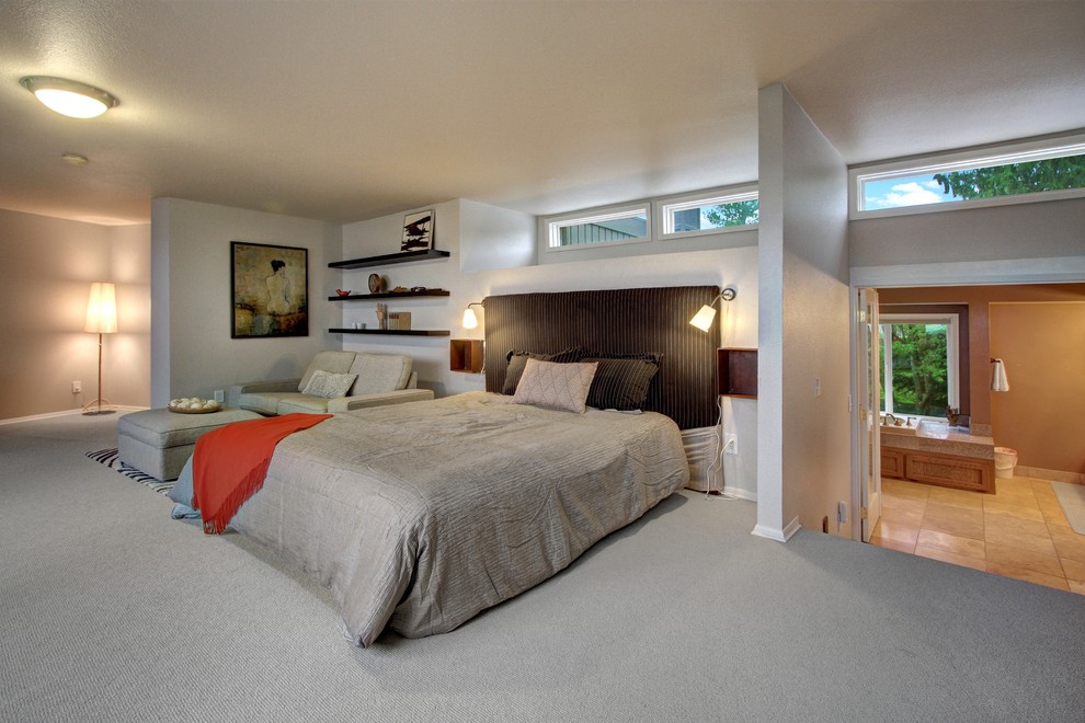 Photo of a large midcentury master bedroom in Seattle with white walls and carpet.