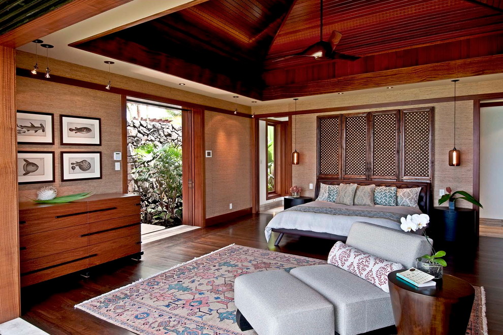 Imagen de dormitorio tropical con paredes beige y suelo de madera oscura