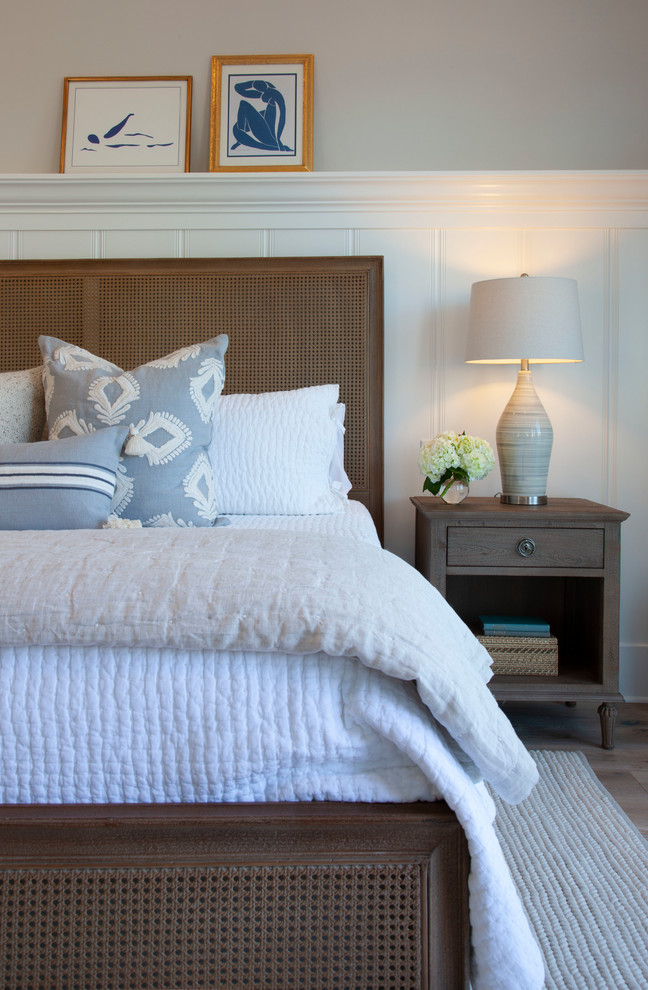 Imagen de dormitorio principal costero de tamaño medio con paredes grises, suelo de madera clara y suelo gris