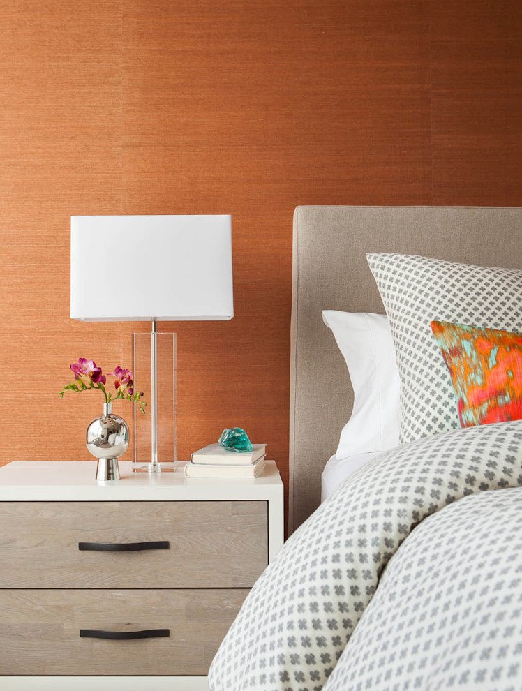 На фото: хозяйская спальня среднего размера в современном стиле с ковровым покрытием и оранжевыми стенами с