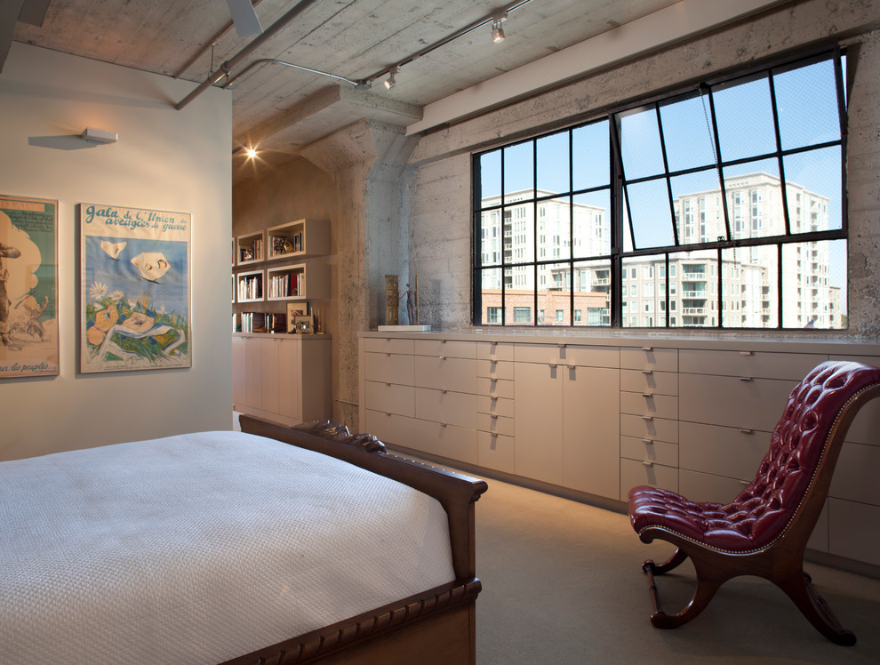 Modelo de dormitorio principal industrial pequeño con paredes beige y moqueta