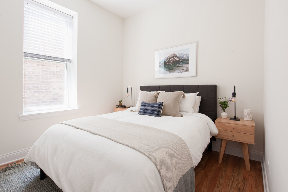 This is an example of a small scandi guest bedroom in Phoenix with white walls and medium hardwood flooring.