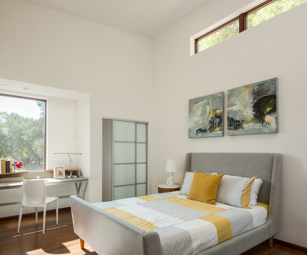 Ispirazione per una grande camera degli ospiti moderna con pareti bianche e pavimento in legno massello medio