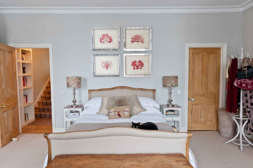 ロンドンにある中くらいなシャビーシック調のおしゃれな主寝室 (ピンクの壁、カーペット敷き、標準型暖炉、木材の暖炉まわり、ベージュの床) のレイアウト