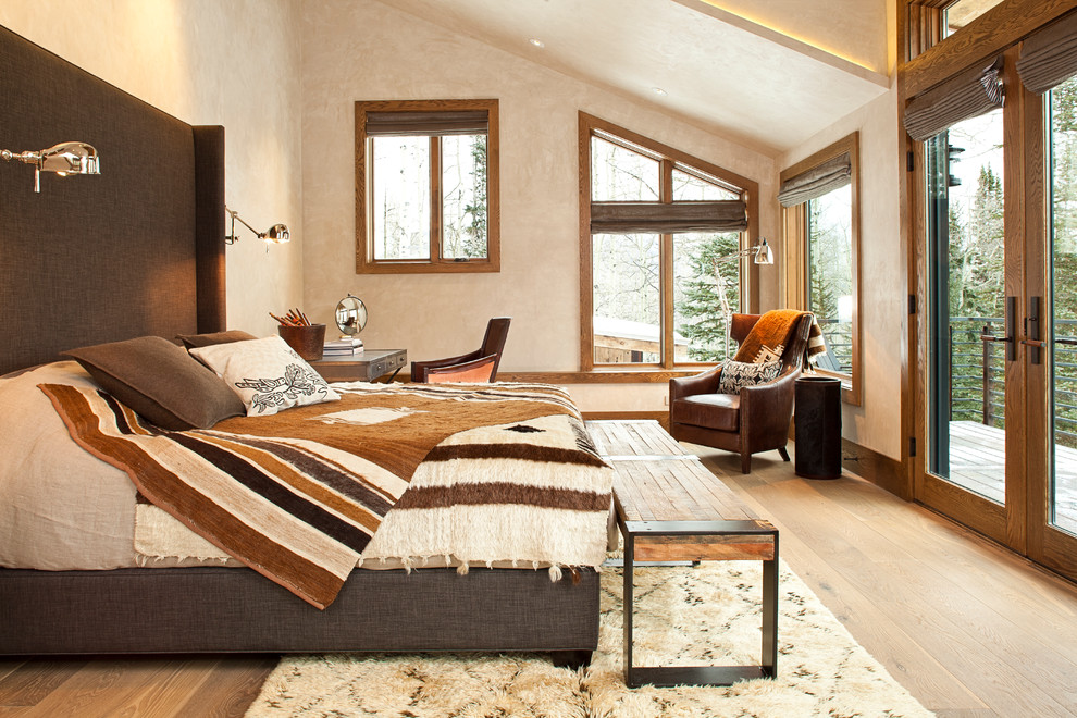 Ejemplo de dormitorio actual con paredes beige, suelo de madera clara y con escritorio