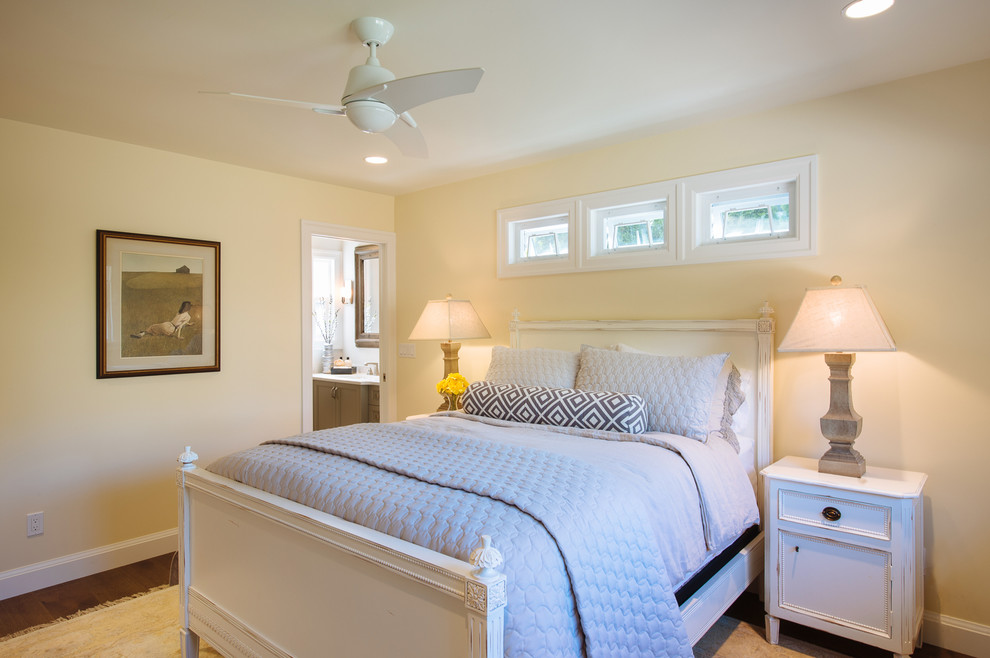 Foto de dormitorio principal romántico de tamaño medio sin chimenea con paredes amarillas y suelo de madera en tonos medios