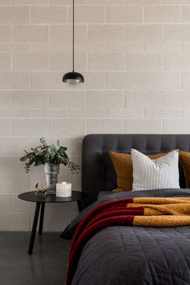 Imagen de dormitorio principal industrial de tamaño medio con paredes grises, suelo de cemento y suelo gris