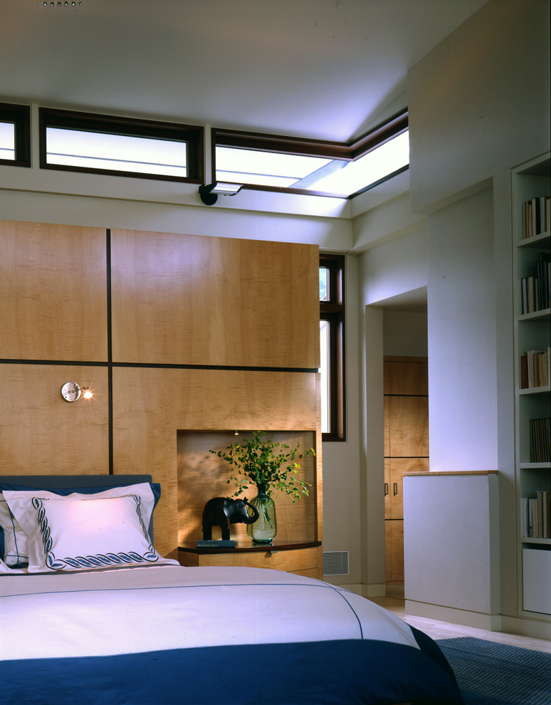 Cette image montre une grande chambre design avec un mur beige, aucune cheminée et un sol bleu.