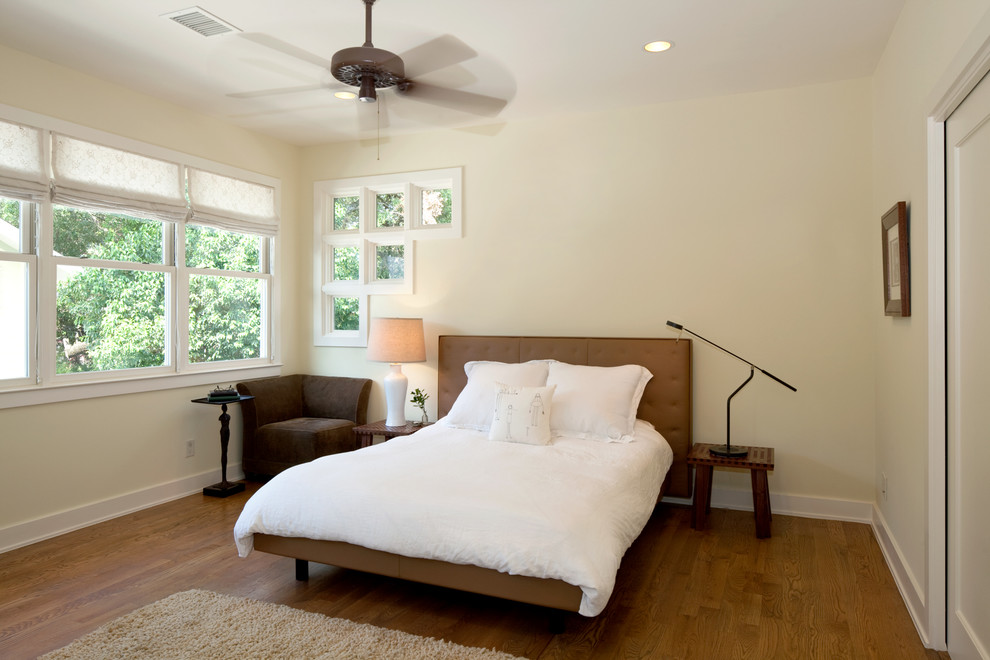 Aménagement d'une chambre éclectique avec un mur beige et un sol en bois brun.