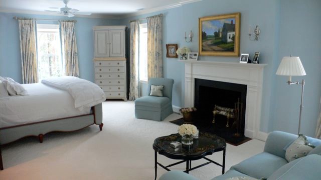 Ejemplo de dormitorio principal clásico de tamaño medio con paredes azules, moqueta, todas las chimeneas, marco de chimenea de madera y suelo beige