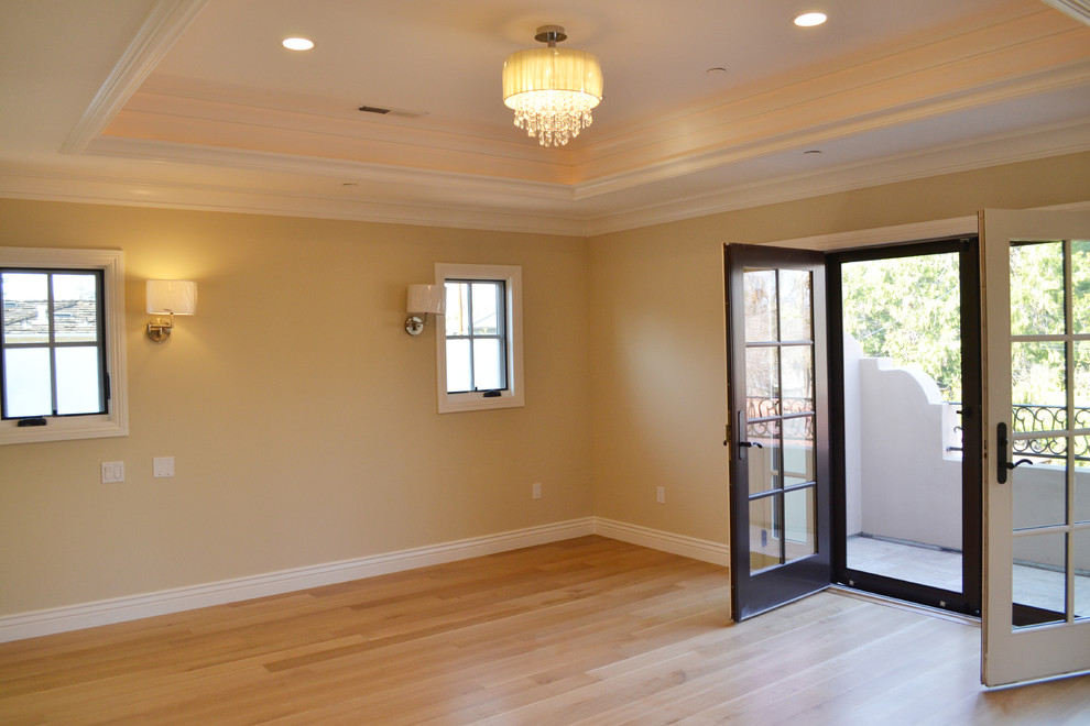 Inspiration for a large traditional master bedroom in San Francisco with beige walls and light hardwood flooring.