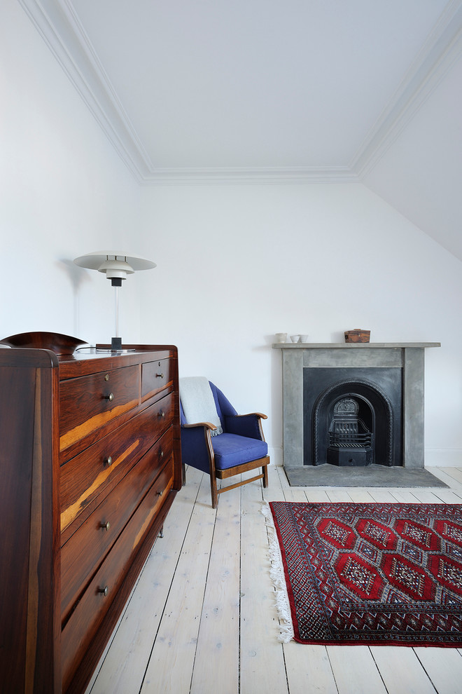 Cette photo montre une grande chambre parentale scandinave avec un mur blanc, parquet clair, une cheminée standard et un manteau de cheminée en pierre.