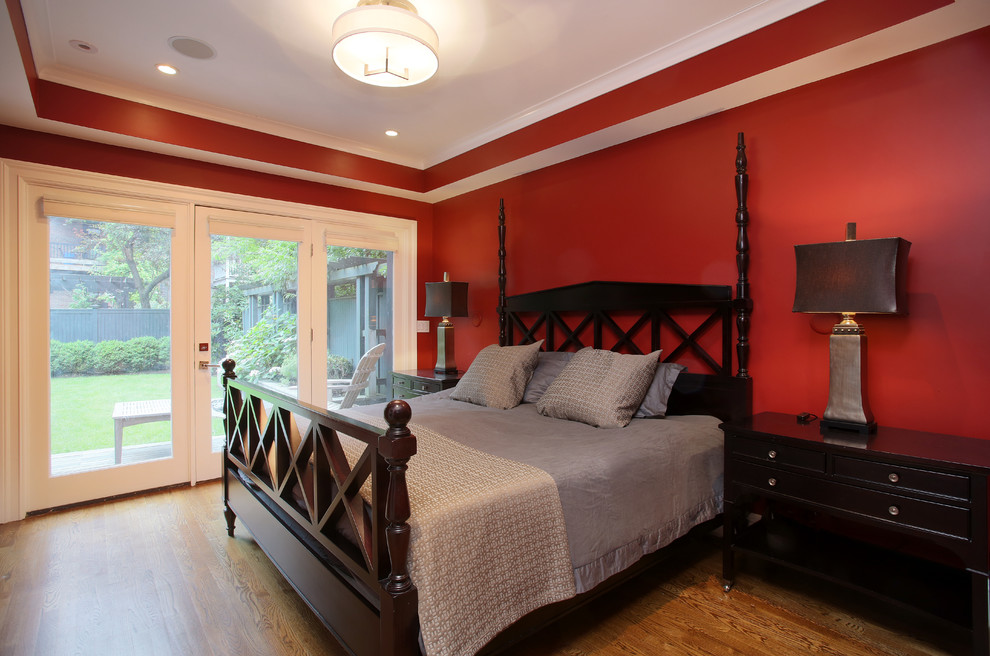 Foto de dormitorio principal tradicional de tamaño medio con paredes rojas y suelo de madera en tonos medios