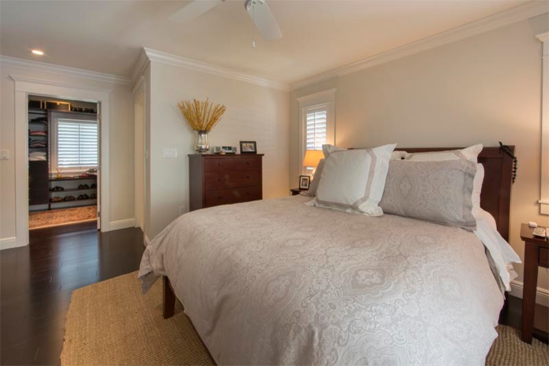Photo of a large classic master bedroom in Miami with beige walls and dark hardwood flooring.