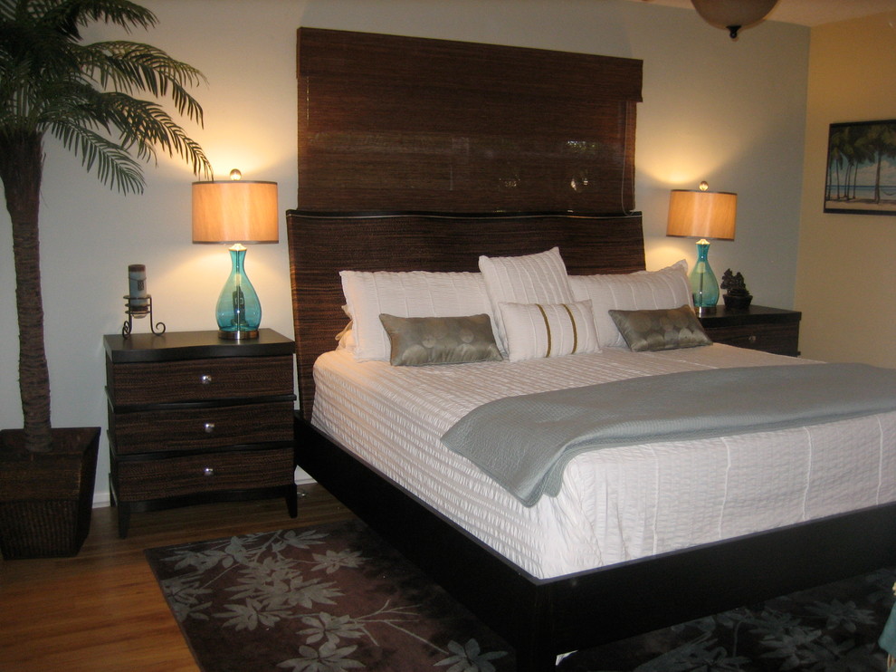 Idee per una camera degli ospiti tropicale di medie dimensioni con pareti blu e pavimento in legno massello medio
