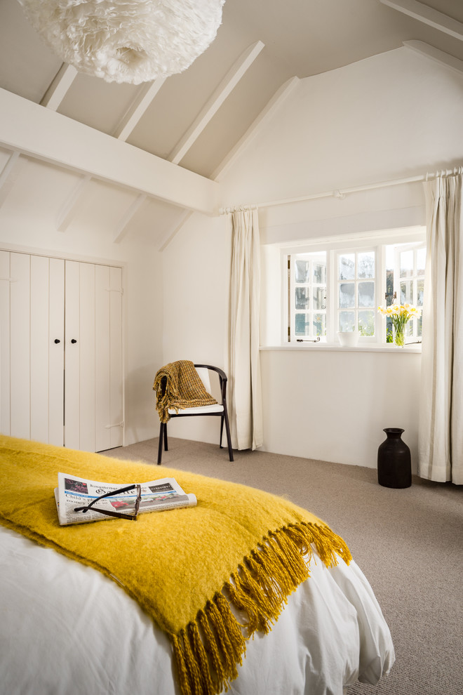 На фото: хозяйская спальня среднего размера в скандинавском стиле с белыми стенами и ковровым покрытием с
