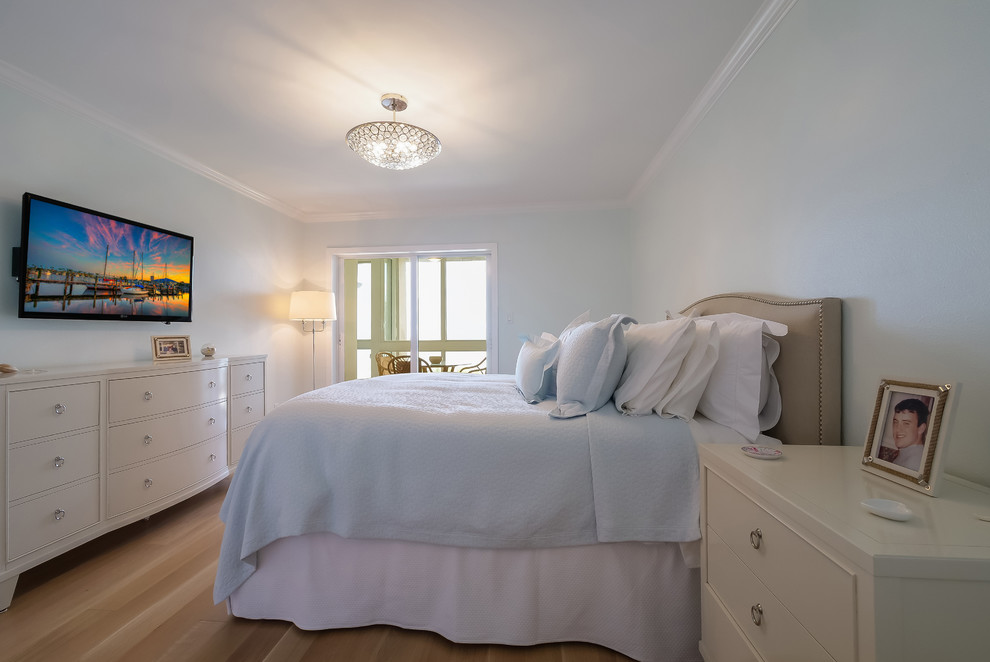 Ejemplo de habitación de invitados tradicional renovada de tamaño medio sin chimenea con paredes azules, suelo de madera clara y suelo marrón