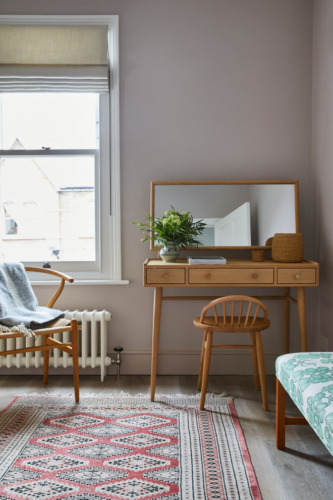 Bedroom - contemporary guest medium tone wood floor bedroom idea in London with pink walls