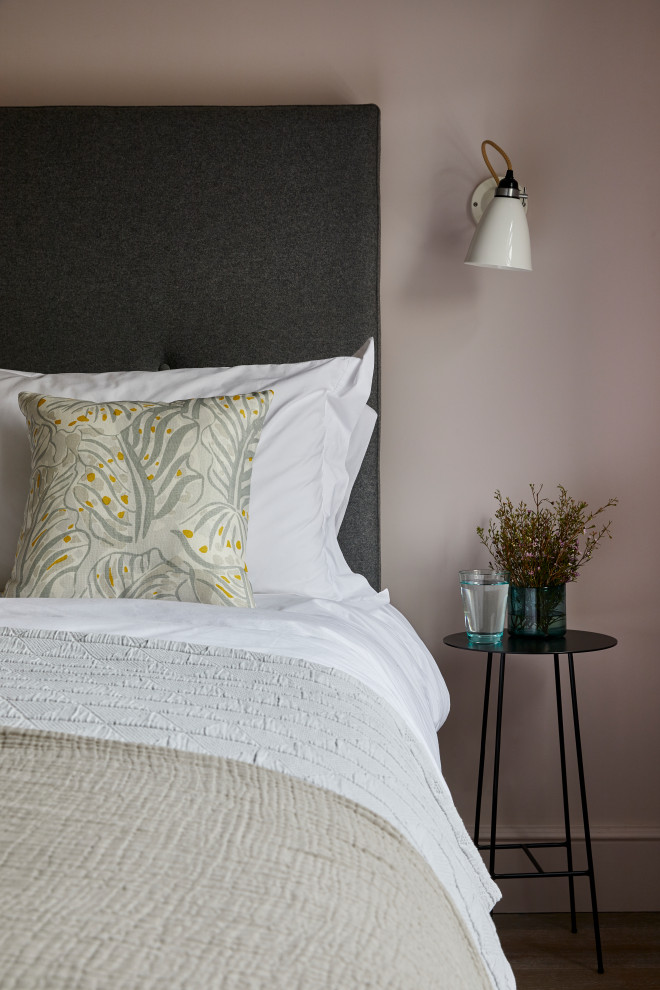 Imagen de habitación de invitados actual con paredes rosas y suelo de madera en tonos medios