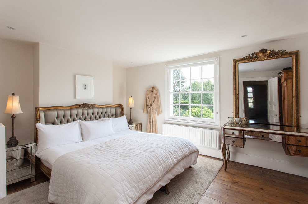 Esempio di una camera da letto classica di medie dimensioni con pareti bianche, pavimento in legno massello medio e pavimento marrone