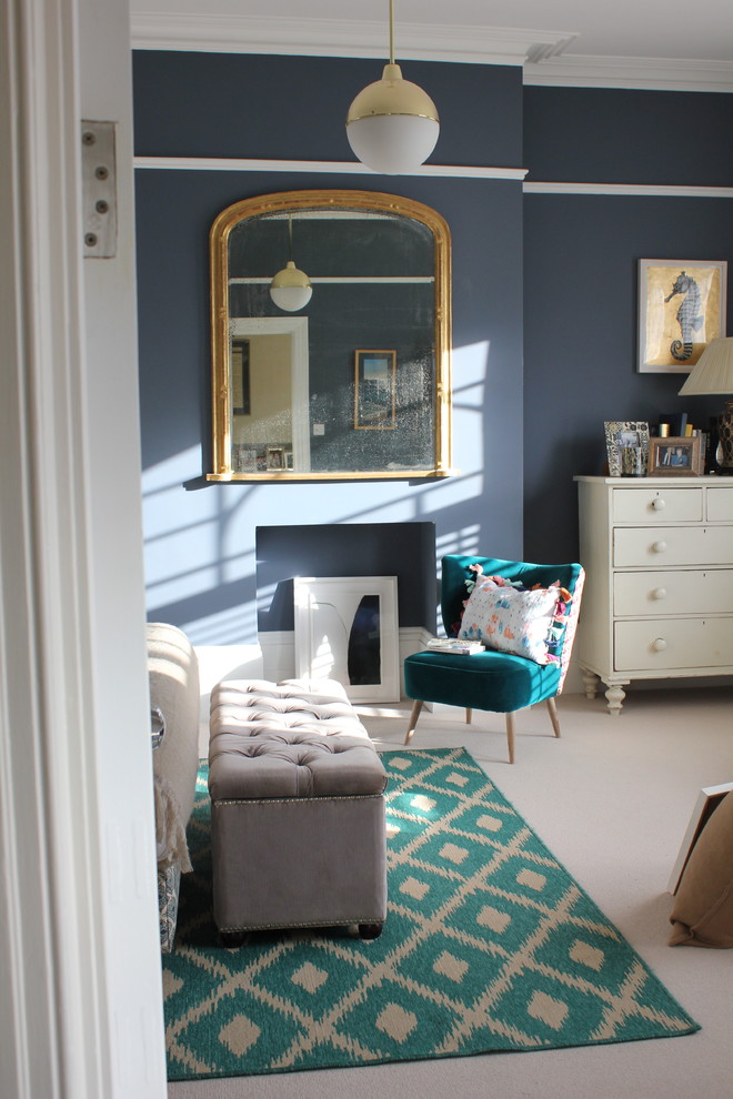 This is an example of a victorian master bedroom in London with blue walls, carpet, a standard fireplace and beige floors.