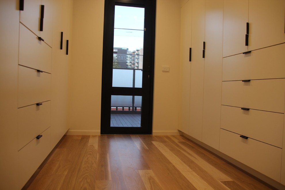 Modernes Hauptschlafzimmer mit hellem Holzboden in Melbourne