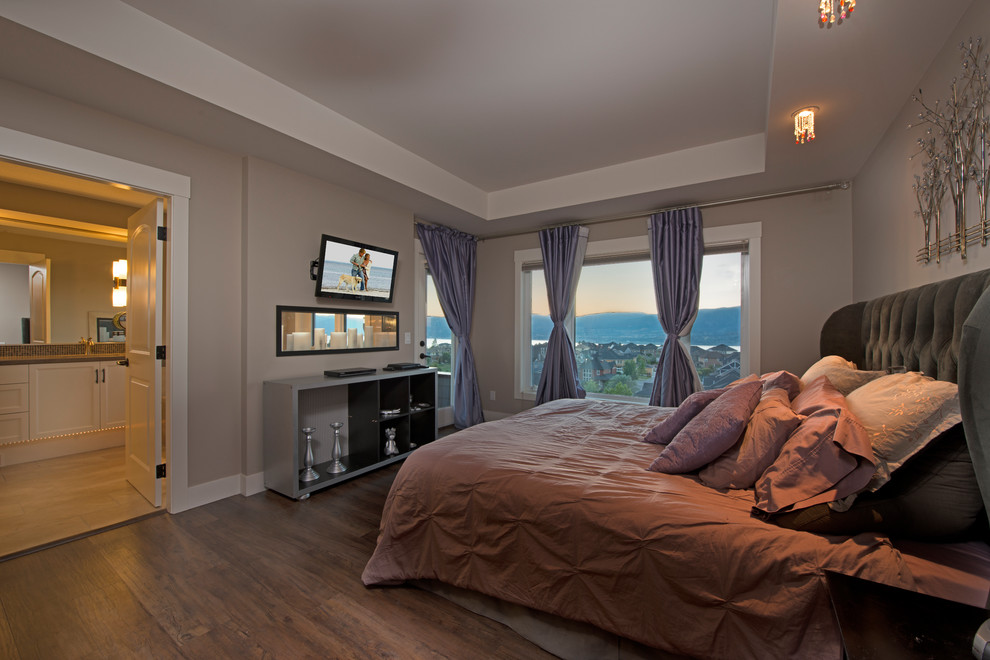 Diseño de dormitorio principal de estilo americano de tamaño medio con paredes grises, suelo de madera en tonos medios y chimenea lineal