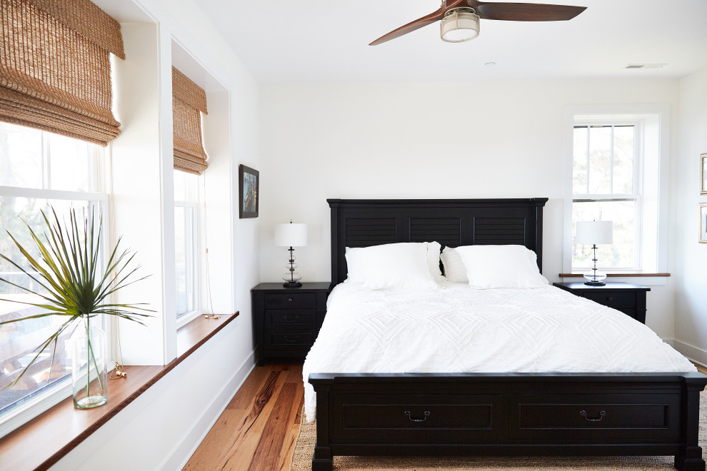 Immagine di una camera degli ospiti stile marino di medie dimensioni con pareti bianche, parquet chiaro e pavimento marrone