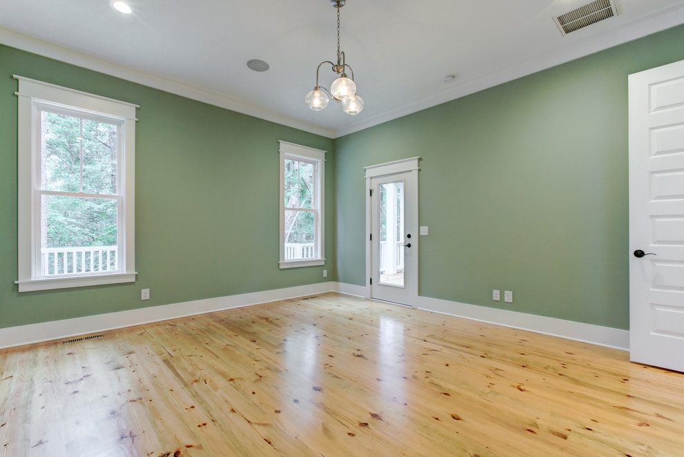 Photo of a large farmhouse master bedroom in Raleigh with green walls, light hardwood flooring and brown floors.