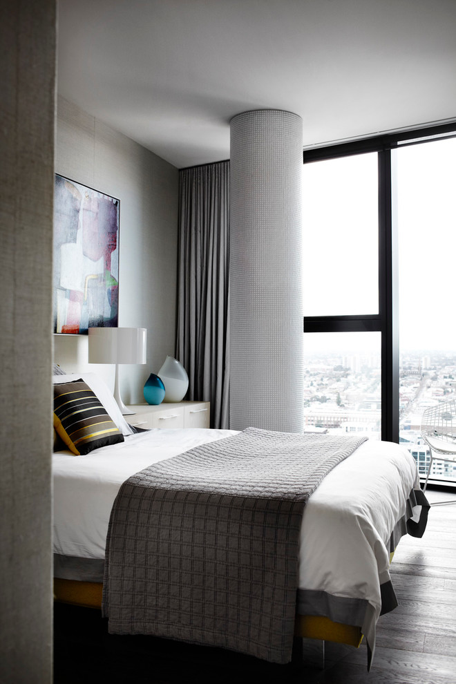 Imagen de dormitorio tipo loft moderno de tamaño medio sin chimenea con paredes grises y suelo de madera en tonos medios