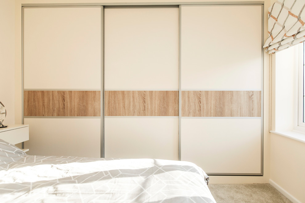Modelo de dormitorio principal contemporáneo de tamaño medio con moqueta, paredes beige y suelo beige