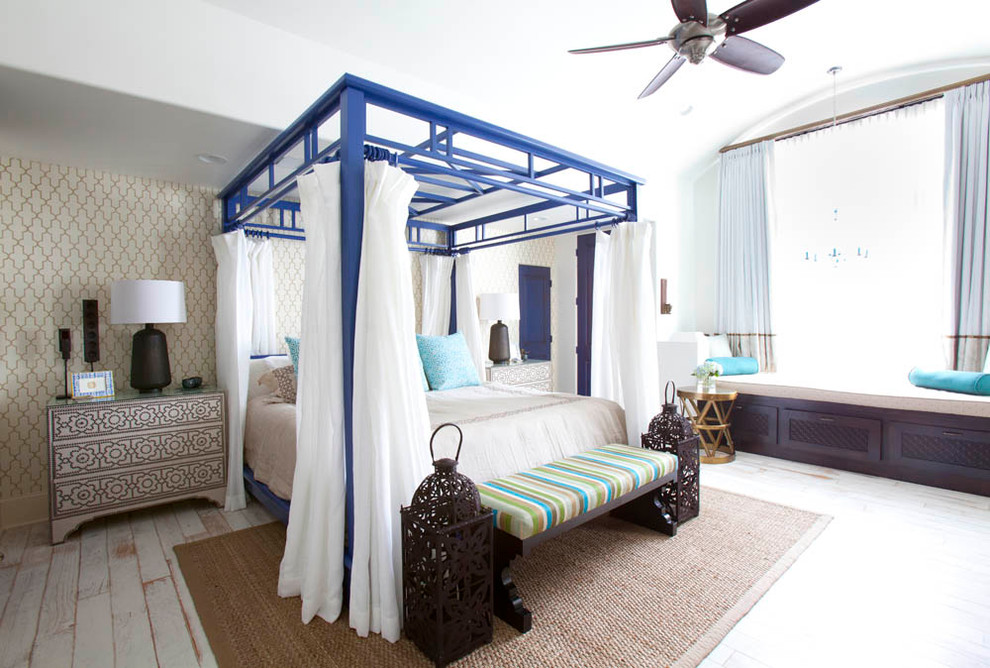 На фото: спальня в средиземноморском стиле с бежевыми стенами и деревянным полом без камина