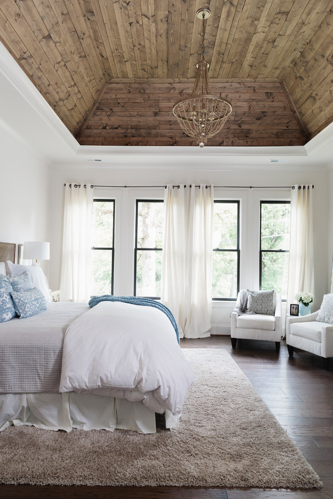 Diseño de dormitorio principal campestre con paredes blancas, suelo de madera en tonos medios y suelo marrón