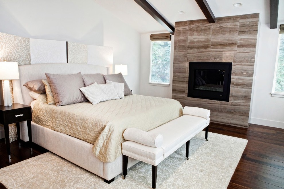 Idées déco pour une chambre parentale classique de taille moyenne avec un mur blanc, un sol en bois brun, une cheminée standard, un manteau de cheminée en carrelage et un sol marron.