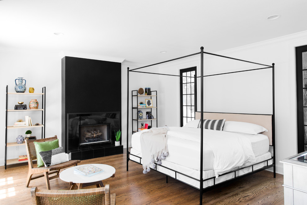 Imagen de dormitorio principal clásico renovado de tamaño medio con paredes blancas, suelo de madera en tonos medios y chimenea lineal