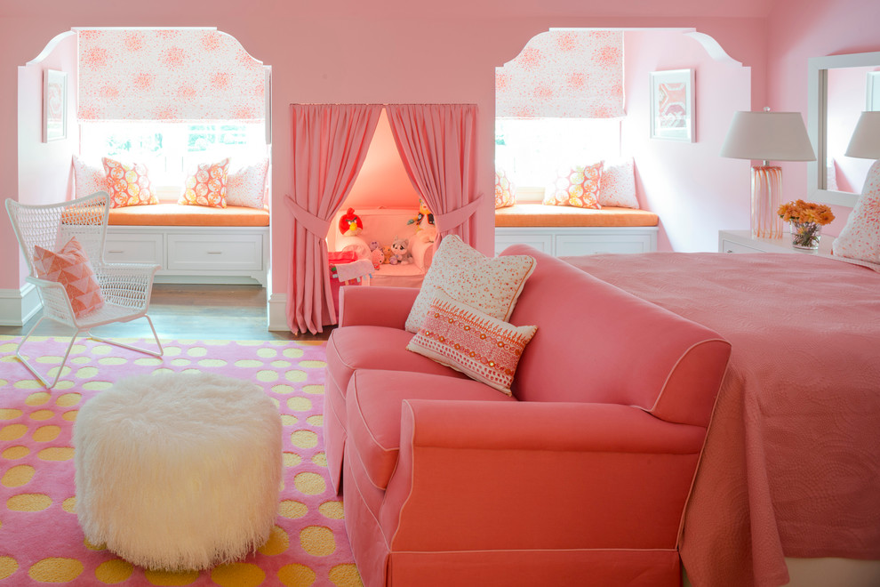 Bild på ett stort sovrum, med rosa väggar och mörkt trägolv