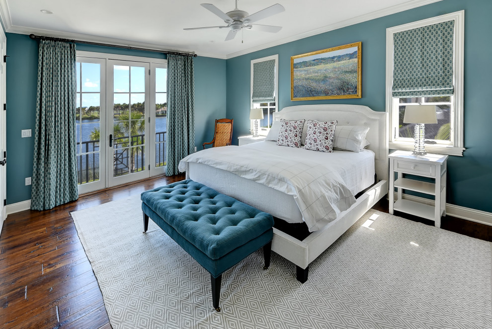 Modelo de dormitorio principal tradicional con paredes azules y suelo de madera en tonos medios