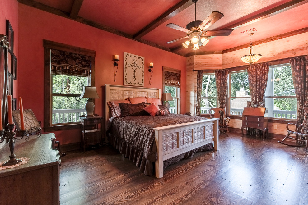 Großes Uriges Hauptschlafzimmer mit roter Wandfarbe und braunem Holzboden in Dallas