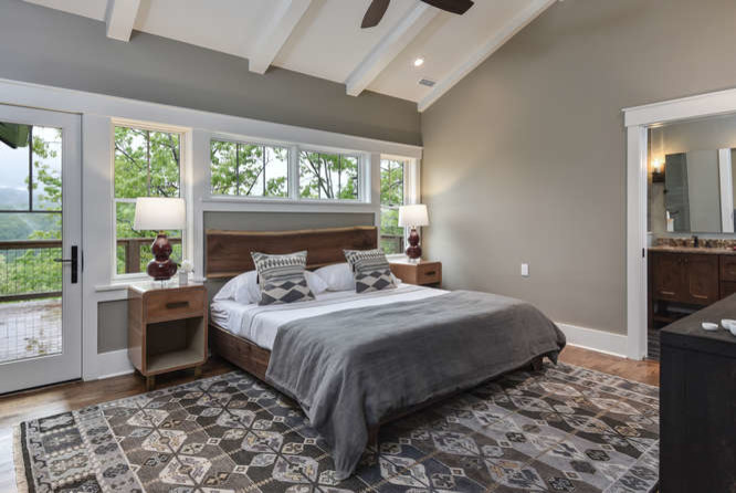 Großes Uriges Hauptschlafzimmer ohne Kamin mit grauer Wandfarbe, braunem Holzboden und braunem Boden in Sonstige