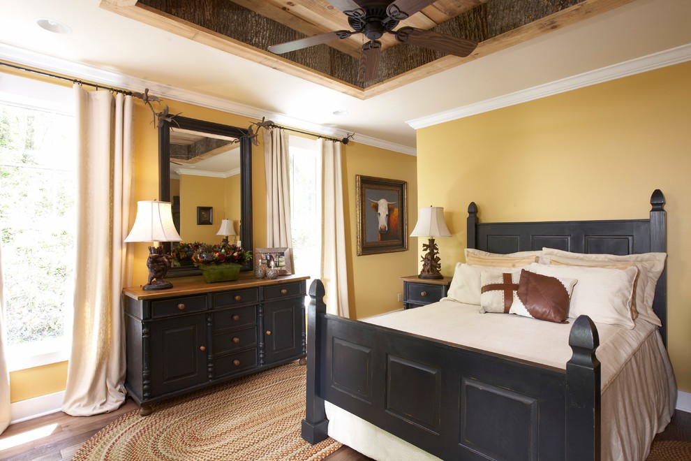 На фото: спальня в стиле кантри с желтыми стенами и паркетным полом среднего тона