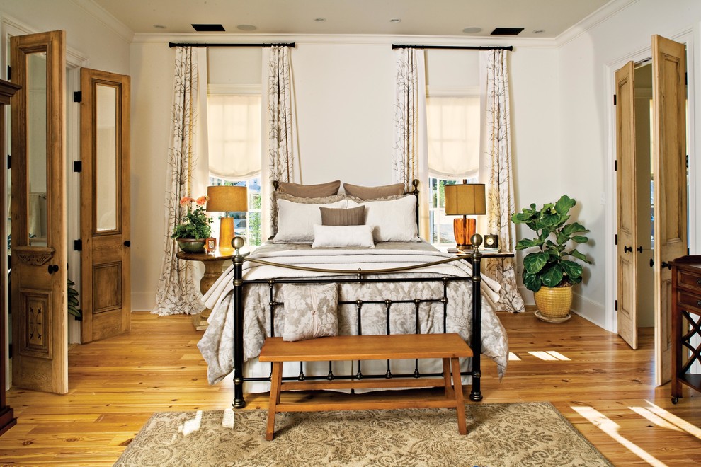 Cette photo montre une chambre chic avec un mur blanc et un sol en bois brun.