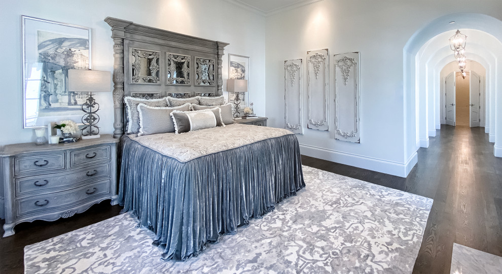 Geräumiges Klassisches Hauptschlafzimmer mit weißer Wandfarbe, dunklem Holzboden, Kamin, gefliester Kaminumrandung, braunem Boden und eingelassener Decke in Dallas