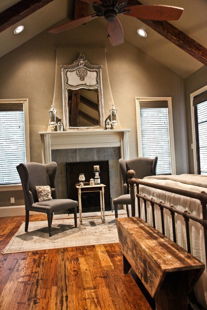 This is an example of a rustic master bedroom in Dallas with beige walls, medium hardwood flooring and a standard fireplace.