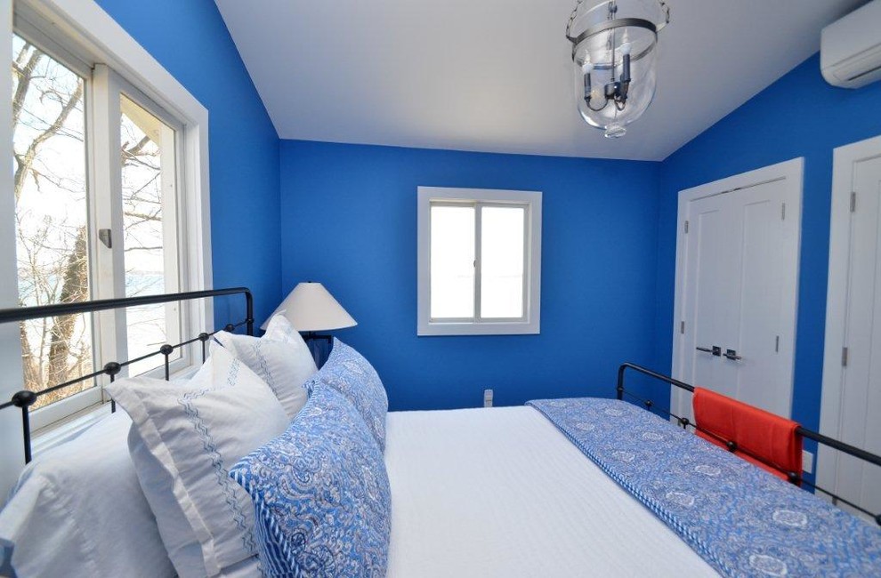 Imagen de dormitorio principal marinero pequeño sin chimenea con paredes azules y suelo de madera clara