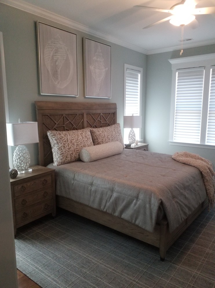 Ejemplo de dormitorio principal costero grande con paredes azules y suelo de madera en tonos medios