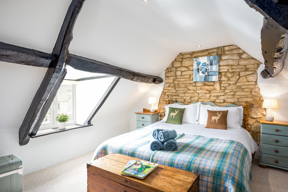 Medium sized rural guest loft bedroom in Gloucestershire with white walls and carpet.