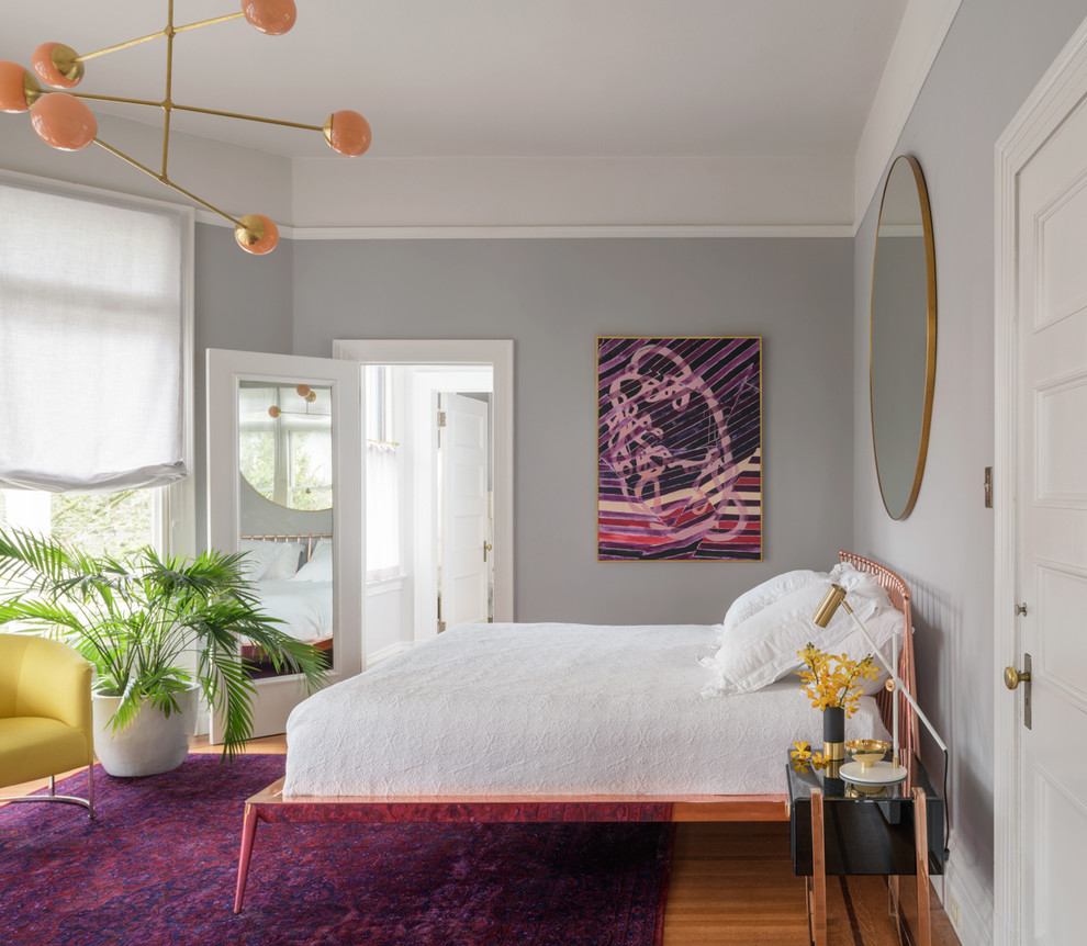 Transitional medium tone wood floor and brown floor bedroom photo in Portland with gray walls