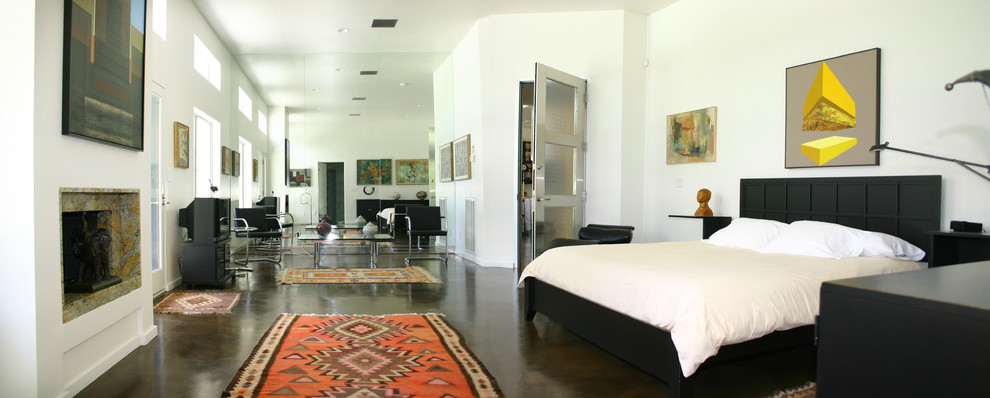 Foto de dormitorio minimalista grande con paredes blancas, suelo de cemento, todas las chimeneas y marco de chimenea de baldosas y/o azulejos